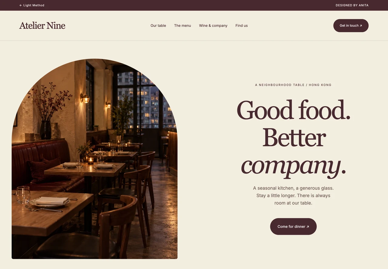 Atelier Nine restaurant homepage with an arched food photograph, elegant serif typography and burgundy menu section